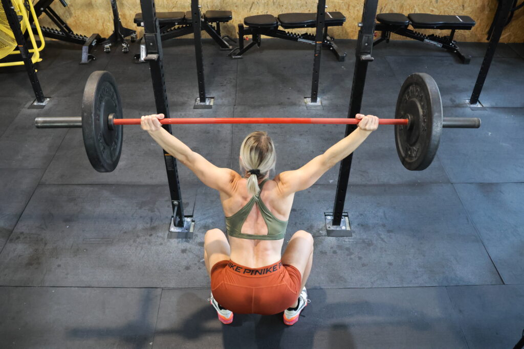 Overhead Squat, Frau beim Training, Langhanteltraining im Functional-Fitness-Bereich